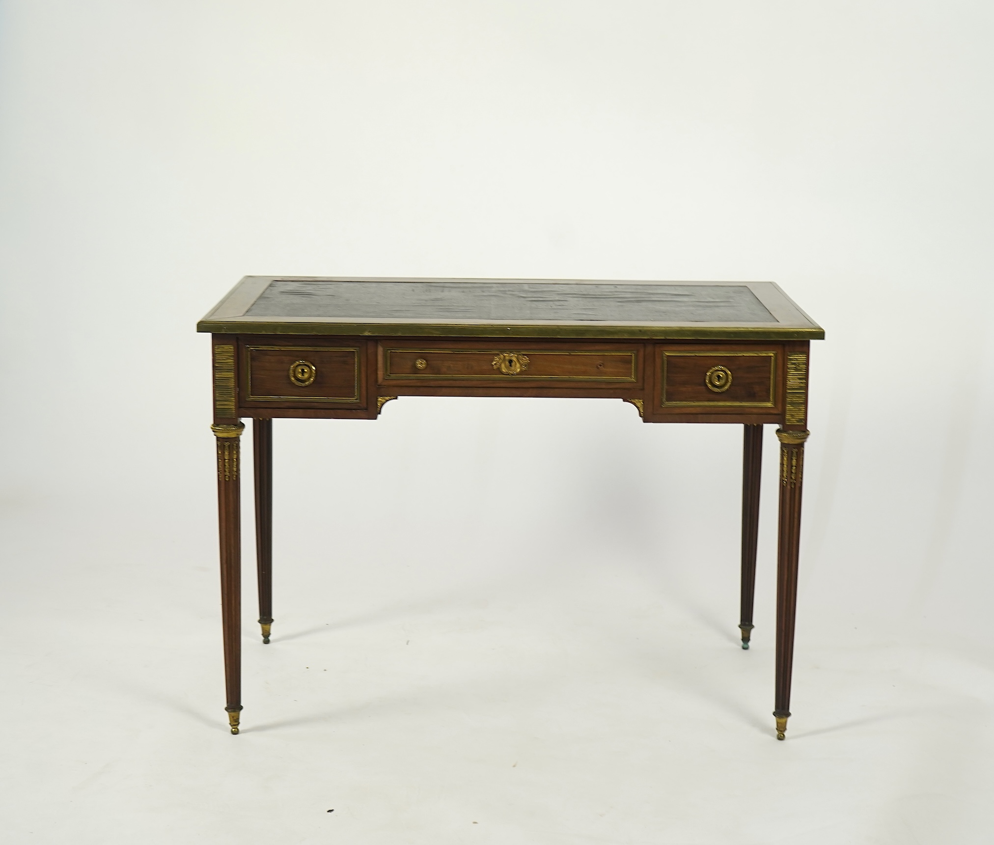 An early 20th century Louis XVI style brass mounted mahogany writing table